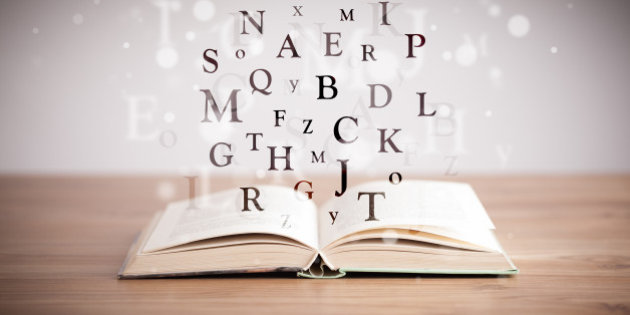 Opened book with flying letters